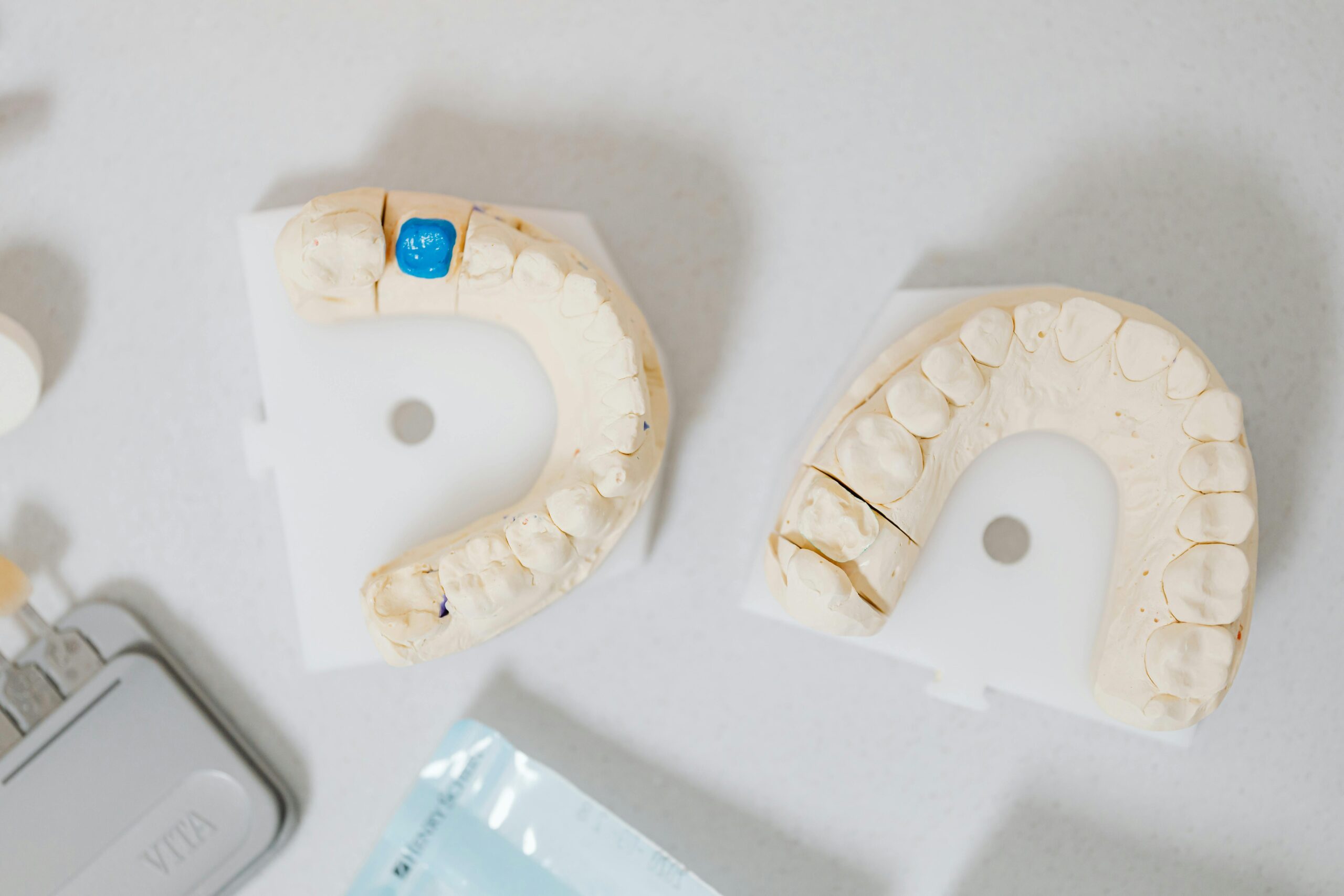 Close-up of a dentist analyzing a dental X-ray on a digital tablet in a clinic setting.